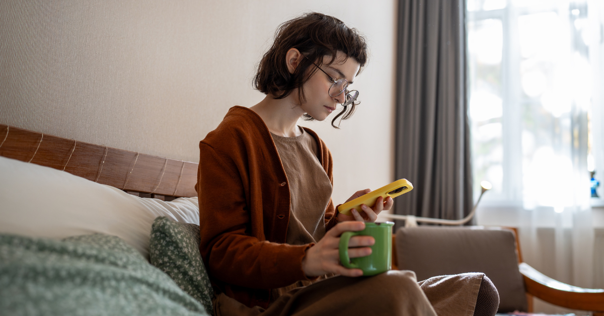 Žena introvertka s mobilom v ruke - aj pre ňu existuje zoznamka, kde sa môže zoznámiť bez tlaku: Dateeo.